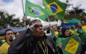 Um apoiador do presidente brasileiro Jair Bolsonaro saúda enquanto canta o hino da nação do lado de fora de uma base militar durante um protesto contra sua derrota na reeleição em São Paulo, Brasil, 3 de novembro de 2022